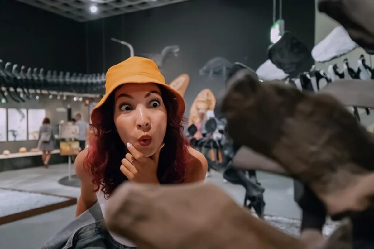 Podekscytowana turystka przygląda się skamieniałym szczątkom dinozaura w Muzeum Historii Naturalnej