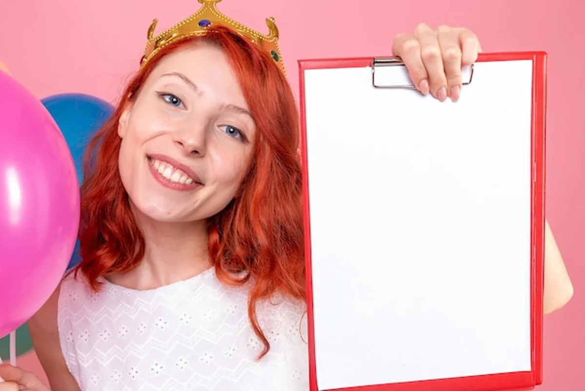 Młoda kobieta trzyma kolorowe balony i plik notatek na różowo