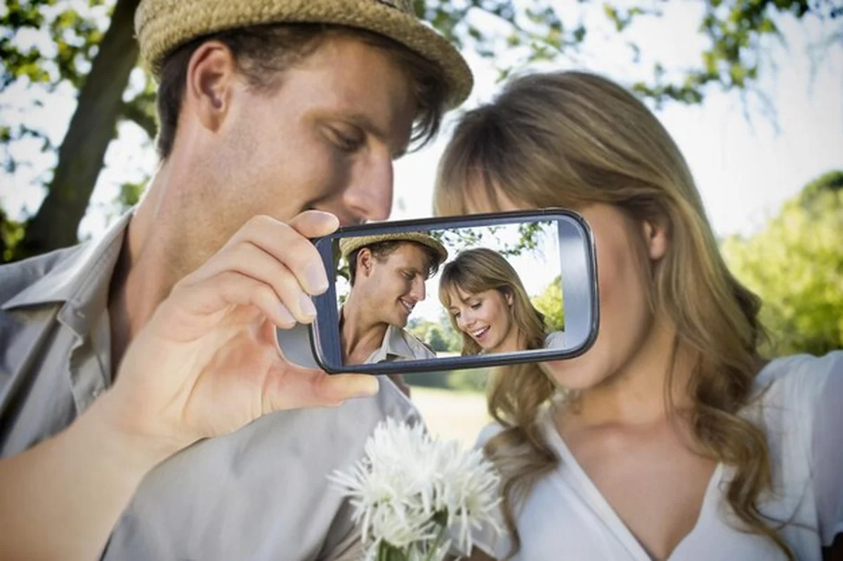 Para robiąca selfie na smartfonie