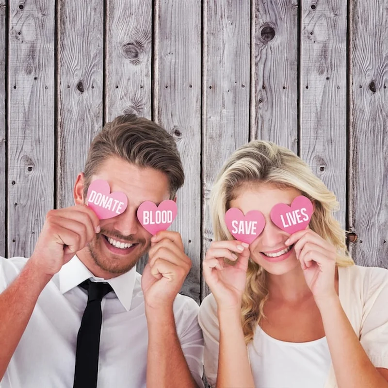 Młoda para trzymająca różowe serca przed szarymi deskami