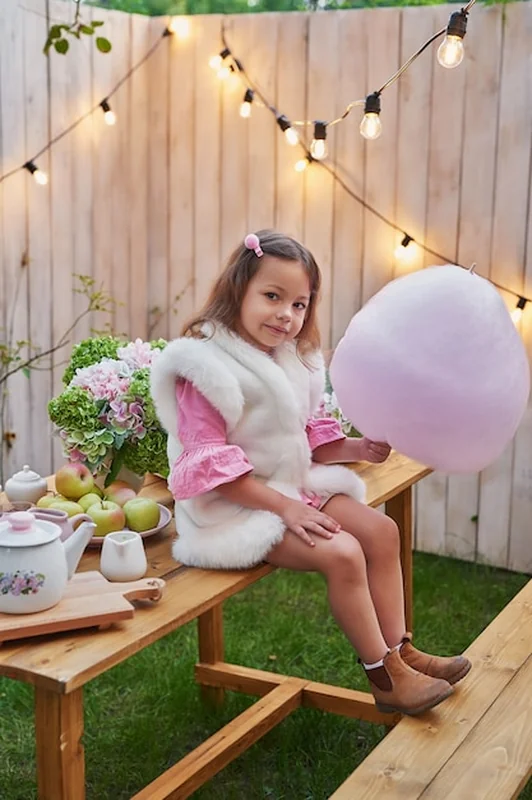 Dziewczynka z watą cukrową na pikniku z kartką życzeń na dzień matki