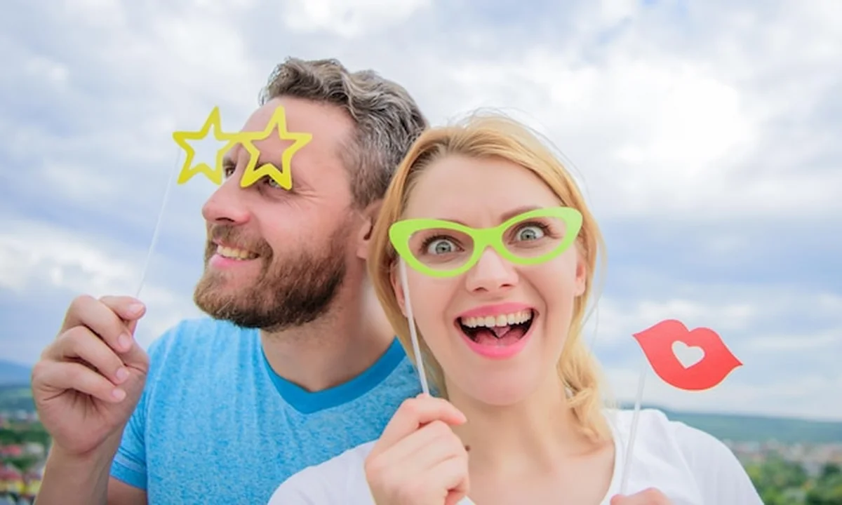 Impreza z fotobudką: kobieta i mężczyzna w rekwizytach do zdjęć