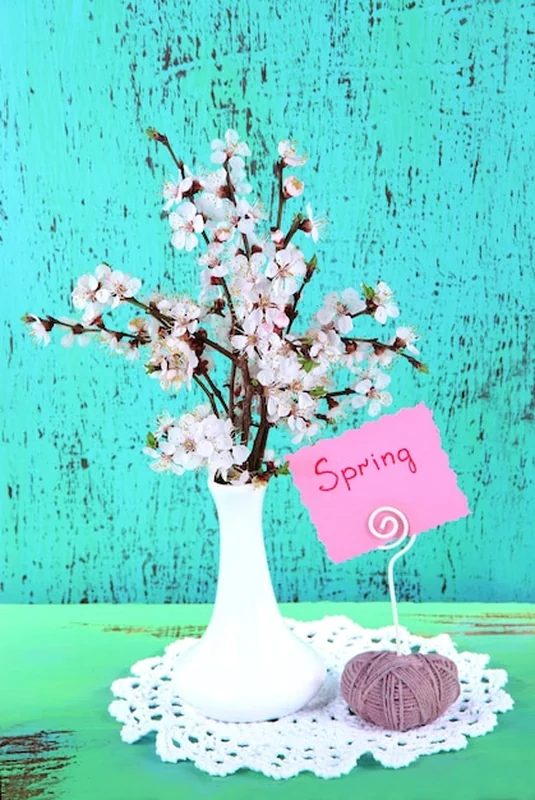 Piękne kwitnące gałęzie w wazonie na niebieskim tle