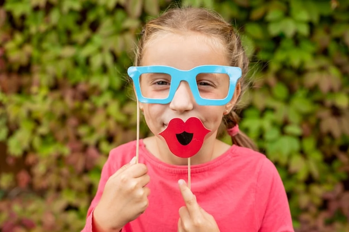 Młoda dziewczyna z rekwizytami do fotobudki przed przyjęciem urodzinowym