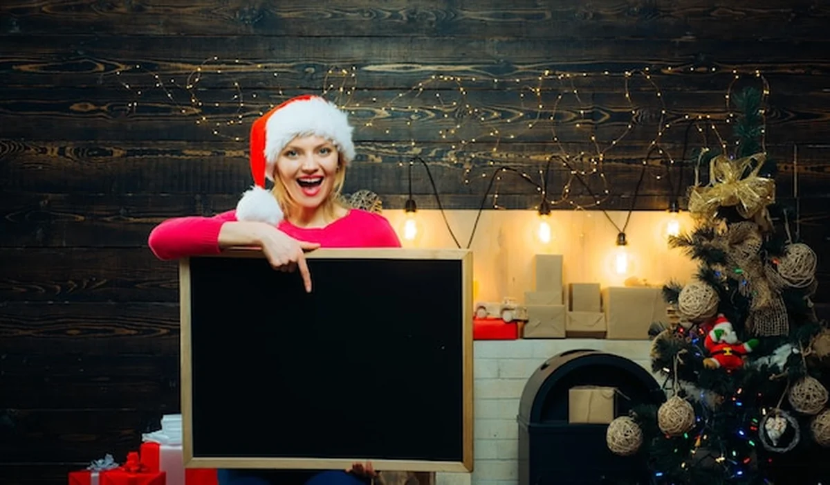 Kobieta trzyma czarne biurko przy czarnej tablicy