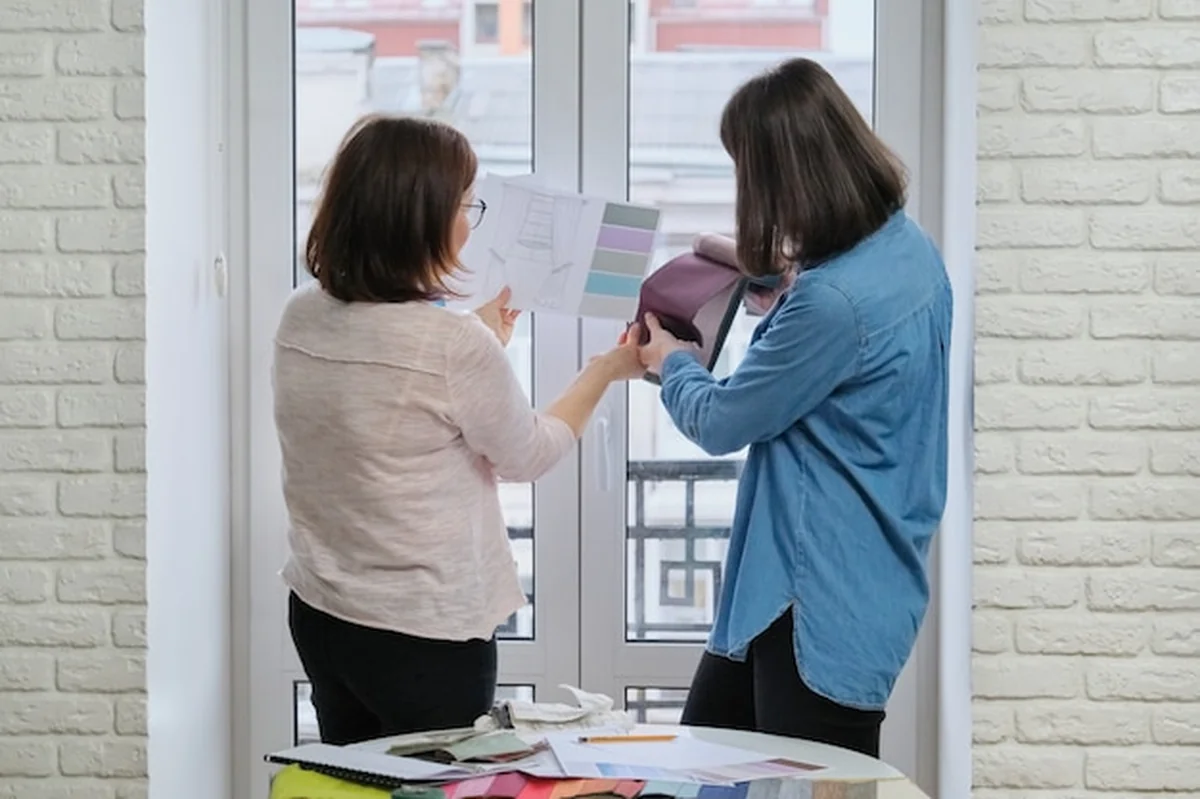 Projektantka i klient pracujący z próbkami tkanin