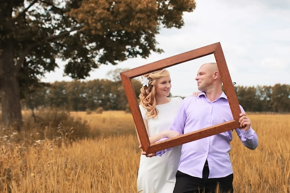 Nowożeńcy spacerujący po polu w jesienny dzień