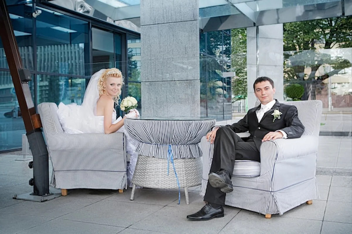 Pan młody i panna młoda z bukietem róż w kawiarni